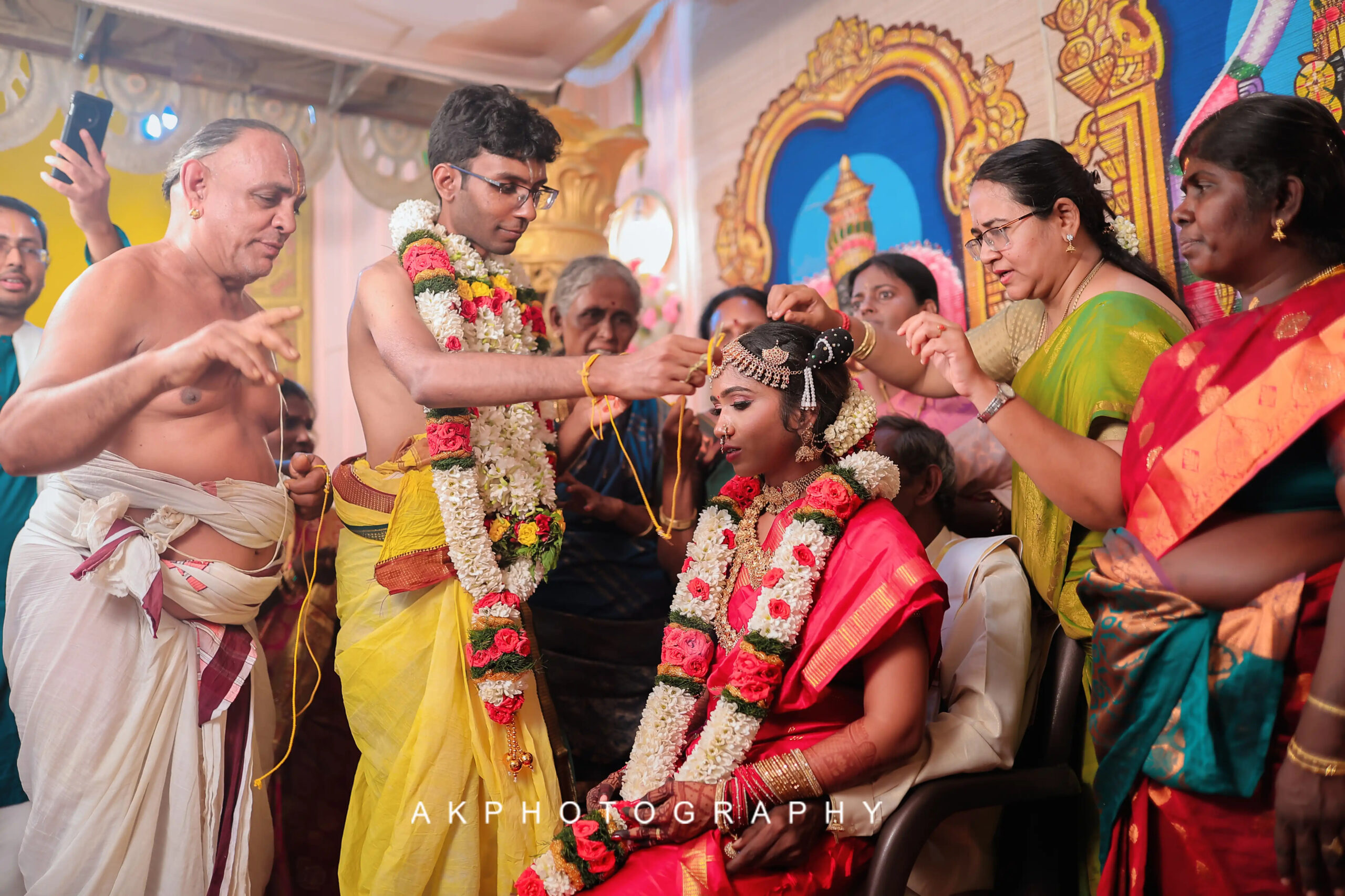 Groom gently placing flowers on bride's head during Kapila & Kokila's Brahmin Wedding Photoshoot. The Art of Storytelling: A Coimbatore Wedding Photographer's Guide